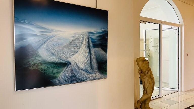 Ein Kunstwerk hängt in einem Ausstellungsraum. Im Schloss Isny würdigt eine Sonderausstellung den Künstler Friedrich Hechelmann.