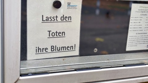 Schild: Lasst den Toten ihre Blumen. Gerade vor Allerheiligen häufen sich Diebstähle auf Friedhöfen.