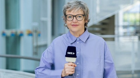 Porträtaufnahme von Ina Held mit Mikrofon in der Hand