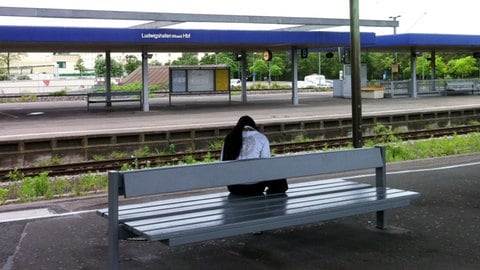 Eine junge Frau sitzt alleine auf einer Bank am Bahnhof Ludwigshafen, wo am Freitag fünf Jugendliche ausgeraubt wurden.
