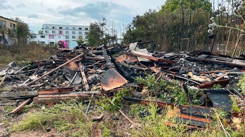 Am Tag nach dem Brand liegt verbranntes Material an der Einsatzstelle an der Mombacher Straße in Mainz. 