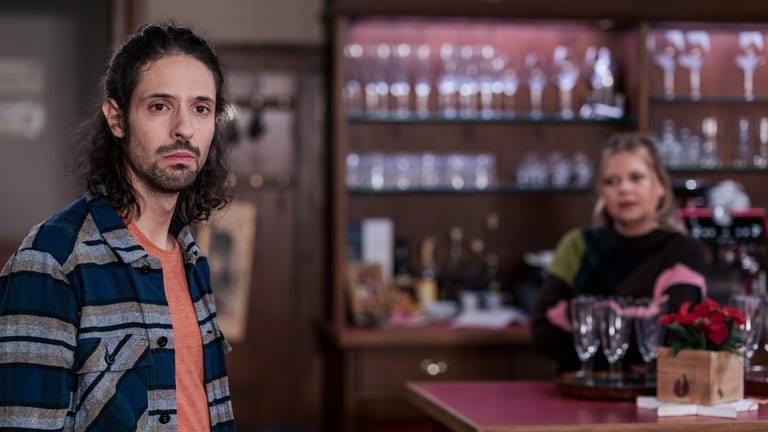 Albert (Alessio Hirschkorn) steht im Löwen, er ist traurig. Im Hintergrund steht Saskia (Mona Schmid) hinterm Tresen.