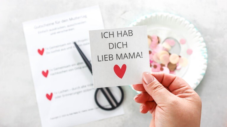 Auf den zweiten, ganzen Pappteller den Gutschein und Konfetti legen.
