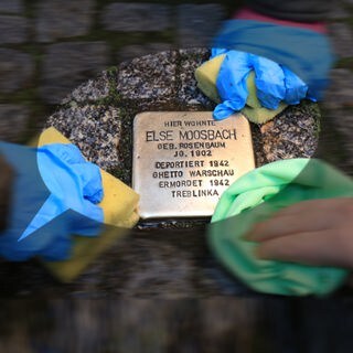 Drei Kinderhände putzen einen Stolperstein in der Lübecker Straße in Magdeburg: Seit Jahrzehnten behandeln Schulen den Holocaust im Unterricht. Trotzdem ist "Jude" auf Schulhöfen als Schimpfwort zu hören und Jugendliche provozieren mit Wörtern wie "vergasen". Viele Lehrkräfte fühlen sich in solchen Situationen überfordert. 