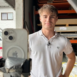 Felix Schröder steht vor seinem Smartphone