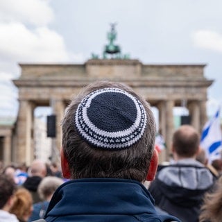 Ein Mann mit Kippa bei einer Demonstration in Berlin vor dem Brandenburger Tor: Mit dem Hamas-Überfall auf Israel 2023 stieg auch der Antisemitismus hierzulande sprunghaft an. Menschen jüdischen Glaubens sind so bedroht wie nie seit dem Zweiten Weltkrieg.