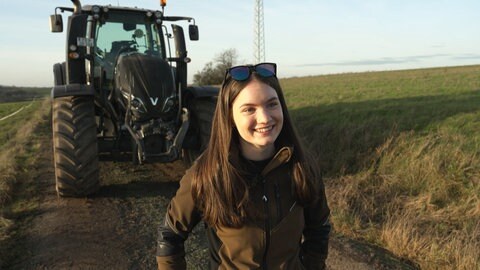 Lena Bauer vor einem Traktor