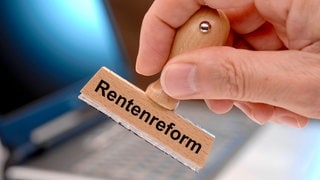 Rentenreform der Deutschen Rentenversicherung Ein Holzstempel ist beschriftet mit dem Aufdruck Rentenreform als Symbolbild für eine umfassende Reform des Rentensystems
