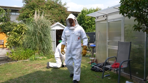 Peter Westermann in einem Schutzanzug in einem Garten. Er ist ehrenamtlicher Asiatische-Hornissen-Nestentferner im Raum RastattBaden-Baden 