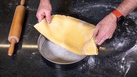 Der ausgerolle Boden aus Mürbteig für den Rhabarberkuchen kommt in die vorbereitete Springform.