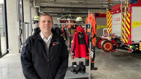 Michael Ehresmann, Pressesprecher der Feuerwehr Mainz, steht vor Feuerwehrwagen in der Feuerwache in der Mainzer Neustadt.