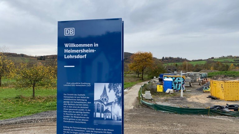 An allen zehn Bahnhöfen und Haltepunkten entlang der Ahrtalbahn stehen Informations-Stelen für Touristen, hier am Haltepunkte Heimersheim-Lohrsdorf. Dort kann man lesen, dass die Bleiglasfenster der Kirche zu den ältesten Glasmalereien Deutschlands zählen.