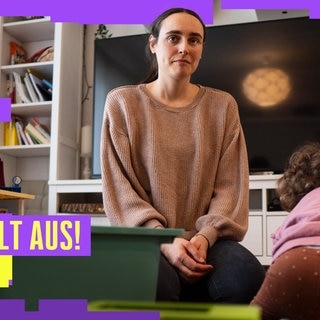 Mutter mit Kind sitzt im Wohnzimmer