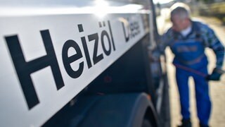 Im Unscharfen Hintergrund sieht man eine Perso, die an einem Heizöl-Lkw hantiert. Vorne ist scharf das Wort Heizöl zu lesen.