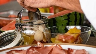 Eberhard Braun nimmt aus einem Einmachglas eingelegte Melonenschalen heraus
