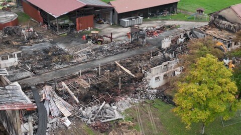 Luftaufnahme der Brandruine. Man erkennt, dass es ein langgezogenes Gebäude war. Oben rechts im Bild das Wohnhaus der Familie Benzing. 