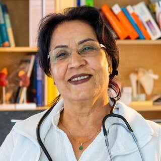 Najiba ist Ärztin und lächelt in die Kamera