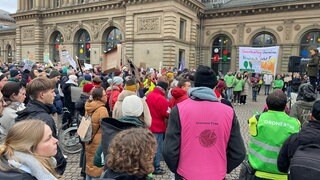Demonstranten mit Fahnen und Plakaten beim Klimastreik vor Bundestagswahl in Mainz am Hauptbahnhof