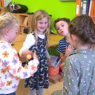Kinder spielen mit einem Tischtennisball