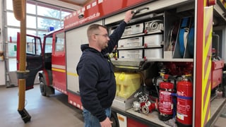 Christian vor einem Feuerwehrauto. Er engagiert sich ehrenamtlich bei der Freiwilligen Feuerwehr in Vendersheim.