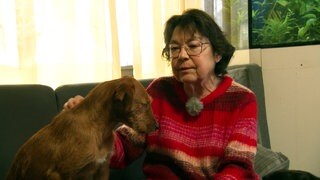 Hündin Pauline sitzt neben ihrer Besitzerin Claudia Beer auf dem Sofa.