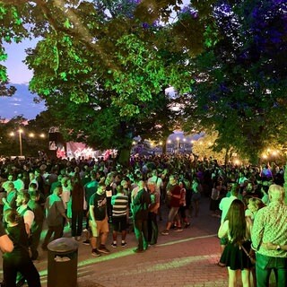 Menschen stehen vor einer Bühne. Das Schlossberg Festival