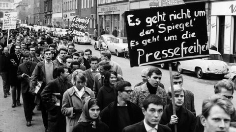 Auf dem Plakat einer Gruppe von Demonstranten steht: "Es geht nicht um den "Spiegel". Es geht um die Pressefreiheit" – In München demonstrierten am 2.11.1962 Studenten gegen die jüngsten Polizei-Maßnahmen in der Hamburger "Spiegel"-Redaktion. Etwa 300 Teilnehmer maschierten mit Spruchtafeln von der Universität zum Königsplatz, wo ein Sprecher die Forderung der Studenten nach Pressefreiheit unterstrich. Im Zuge der "Spiegel"-Affäre mussten sich Mitarbeiter des Nachrichtenmagazins "Spiegel" wegen eines kritischen Artikels gegen eine Anklage des Landesverrats zur Wehr setzen.