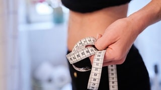 Eine Frau hält ein Zentimetermaßband an ihren Bauch. Das Pfalzklinikum behandelt immer mehr Mädchen mit Essstörungen - auch ambulant. 