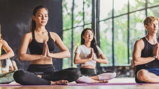 Frauen und Männer machen Yoga