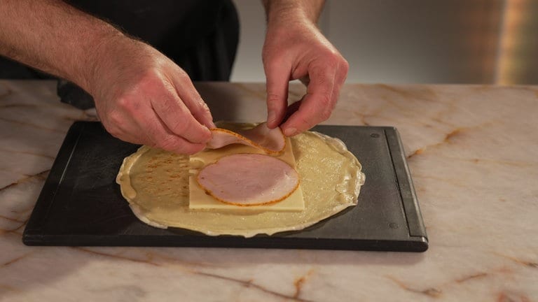 Das Flädle mit Käse und Schinken belegen.