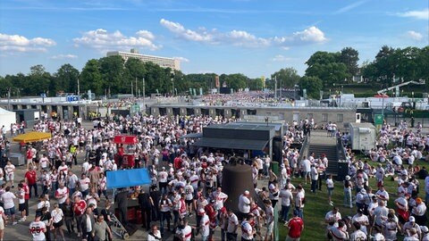 VfB-Fans warten hinter dem Eingang des Olympiastadions an den Bierständen