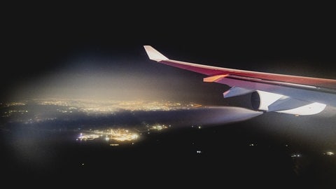 Flugzeug fliegt bei Nacht und lässt Kerosin ab