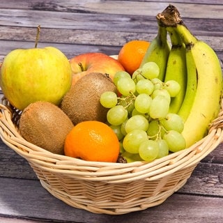 Ein Korb mit frischem Obst: Gesunde Ernährung ist auch eine Frage des Timings. Kohlehydrate werden z.B. morgens besser verstoffwechselt als nachmittags. 