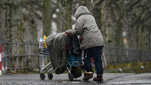 Ein Obdachloser schiebt bei Kälte einen Einkaufswagen. In der Region Bodensee-Oberschwaben gibt es in vielen Kommunen Hilfe für Menschen, die im Winter auf der Straße leben.