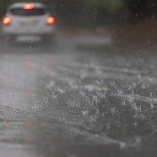 Wasser steht nach einem Regenguss durch ein Gewitter auf einer Straße in Mainz-Laubenheim. 