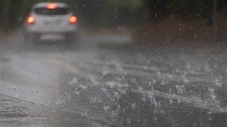 Wasser steht nach einem Regenguss durch ein Gewitter auf einer Straße in Mainz-Laubenheim. 