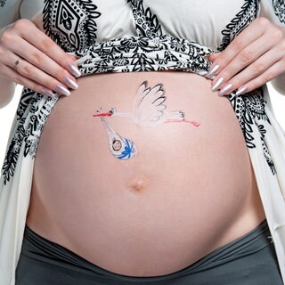 Bauch einer schangeren, darauf gemalt ein Storch, der ein Baby bringt, das in weiße Tücher verpackt ist, die mit einem blauen Band gehalten werden: Es gibt sehr viele Mythen oder Ammenmärchen in Bezug auf die Schwangerschaft. Sehr viele davon beschäftigen sich mit der Prädiktion, also mit der Vorhersage des Geschlechts.