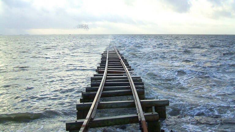 Bei Flut enden die Schienen der Lorenbahn manchmal im Nirgendwo. Deshalb können die Bewohner nur bei Ebbe oder Niedrigwasser auf ihre Hallig fahren.