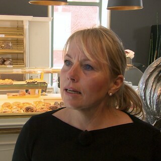 Frau steht vor einer Bäckerei-Theke