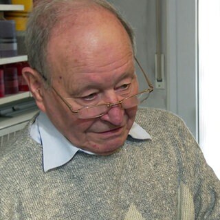 Der 87-jährige Heinz Rittberger steht in seinem Seifenladen in Stuttgart. Neben ihm steht eine Waage.