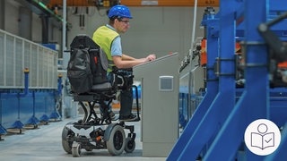 Ein Mann arbeitet an einer Maschine. Der Mann hat einen blauen Helm auf dem Kopf. Der Mann sitzt in einem speziellen Rollstuhl. Rechts das SWR Logo für Leichte Sprache.