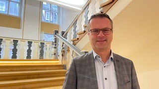 Oberbürgermeister Stephan Neher von der CDU im Treppenhaus des Rottenburger Rathauses. Er kritisiert Kanzlerkandidat Friedrich Merz von der CDU scharf für dessen Zusammenarbeit mit der AfD.