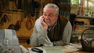 Hermann steht an der Theke im Hofladen und hat seinen Kopf auf die Hand gestützt