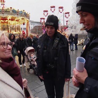 Polizistinnen klären eine Passantin auf