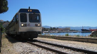 Einfahrt in Ajaccio an der Westküste. Die Gleise verlaufen entlang des Hafenbeckens.