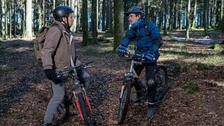 Sebastian und Sam mit ihren Fahrrädern im Wald