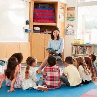 Eine Frau liest Kindern aus einem Buch vor | Aktion "Mehr Lesepaten für Rheinland-Pfalz"