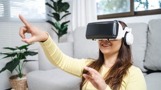 Eine Junge Frau trägt ein Virtual Reality-Headset | Kann man mit Virtual Reality einen schönen Urlaub verbringen?