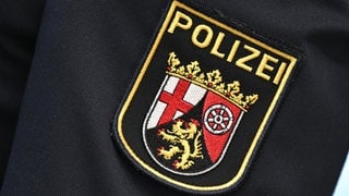 Das Logo der Polizei Rheinland-Pfalz auf einer Uniform (Symbolbild).