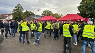 Demonstrierende stehen bei einer Kundgebung.